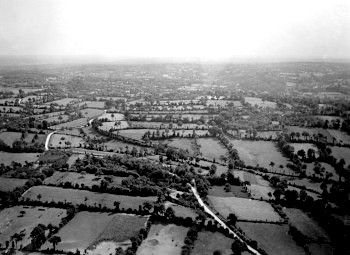 Photographie aérienne en noir et blanc d’un paysage bocager (champs et prés bodés de haies arborées)
